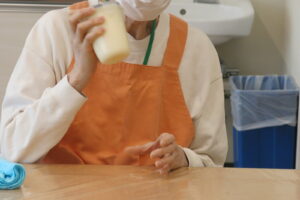 タッパーに入った生クリームをシェイクしている写真