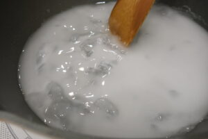 フライパンで水まんじゅうの素を加熱。徐々に固まり始めている様子。